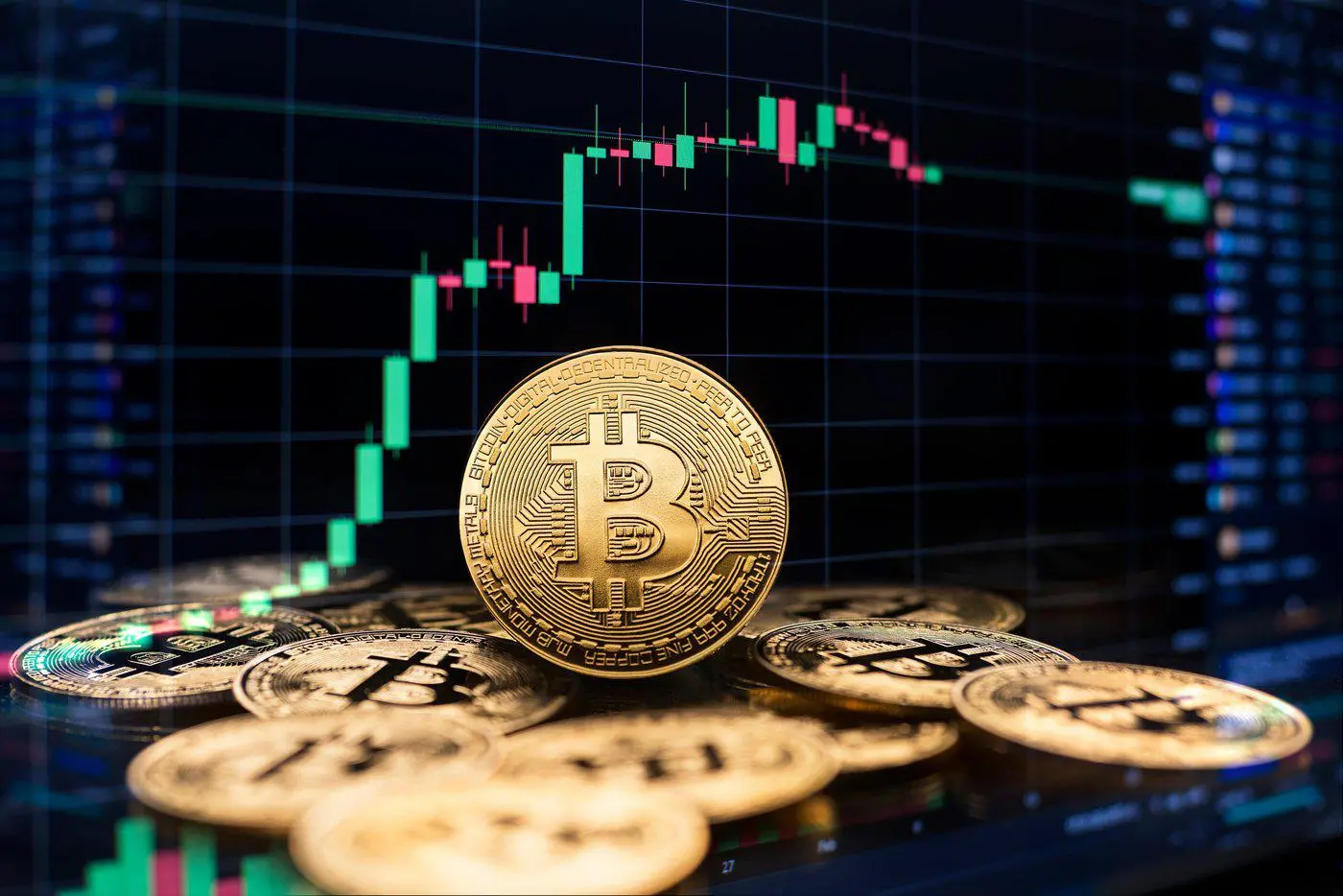 Pièces Bitcoin devant graphique de trading